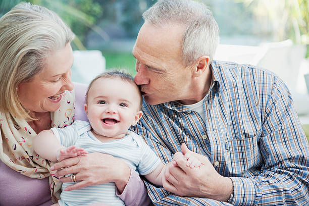 abuelos retención bebé nieto - abuelo y bebe fotografías e imágenes de stock