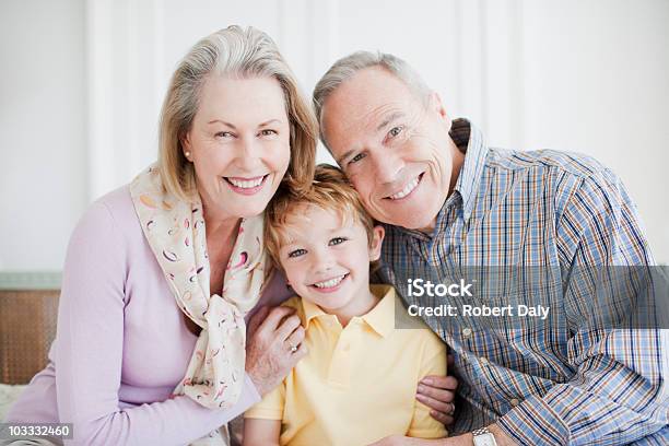 Uśmiechająca Się Dziadkowie Objąć Wnuk - zdjęcia stockowe i więcej obrazów 4 - 5 lat - 4 - 5 lat, 60-64 lata, Aktywni seniorzy