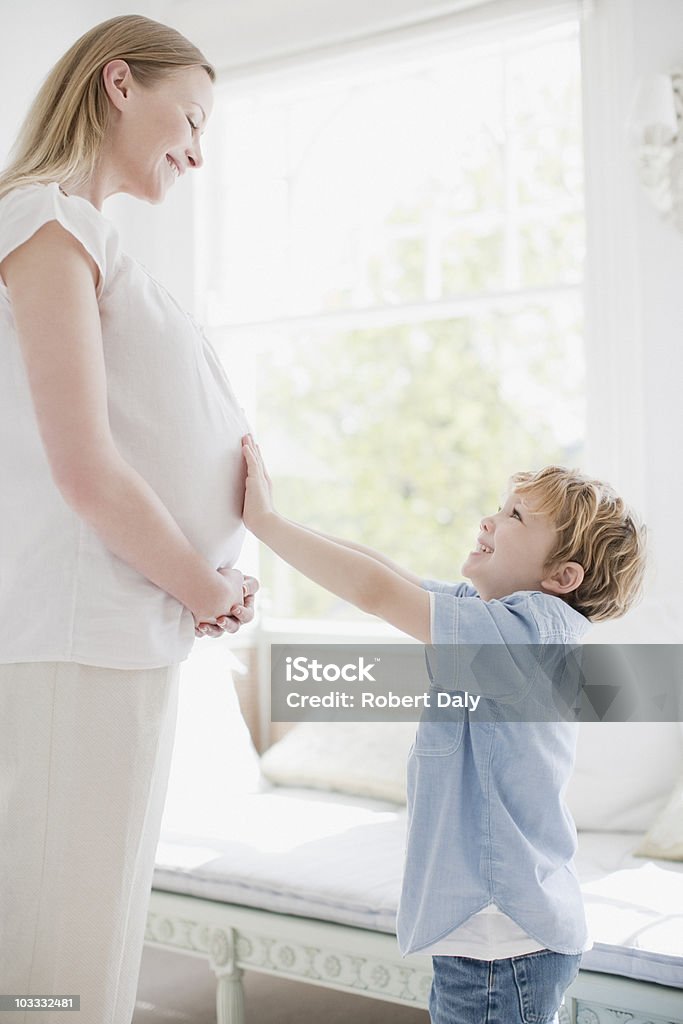 Souriant son toucher les femmes enceintes ventre - Photo de Être enceinte libre de droits