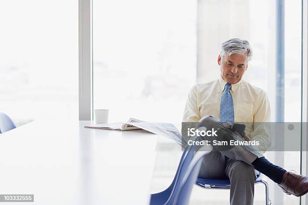 Businessman Text Messaging On Cell Phone In Cafeteria Stock Photo - Download Image Now