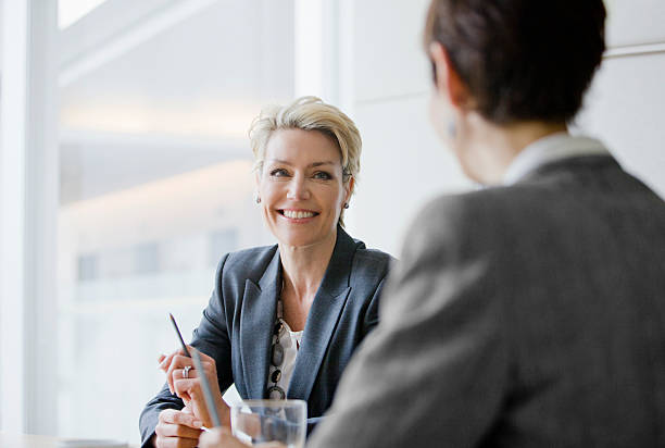 Smiling businesswomen in meeting  business meeting 2 people stock pictures, royalty-free photos & images