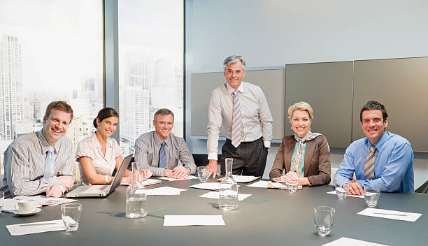 ビジネス人々が笑顔でのミーティングのコンファレンスルーム - hands clasped men table computer ストックフォトと画像