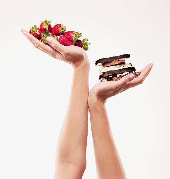 frau beim schröpfen erdbeeren über schokolade bars - strawberry fruit single object food stock-fotos und bilder