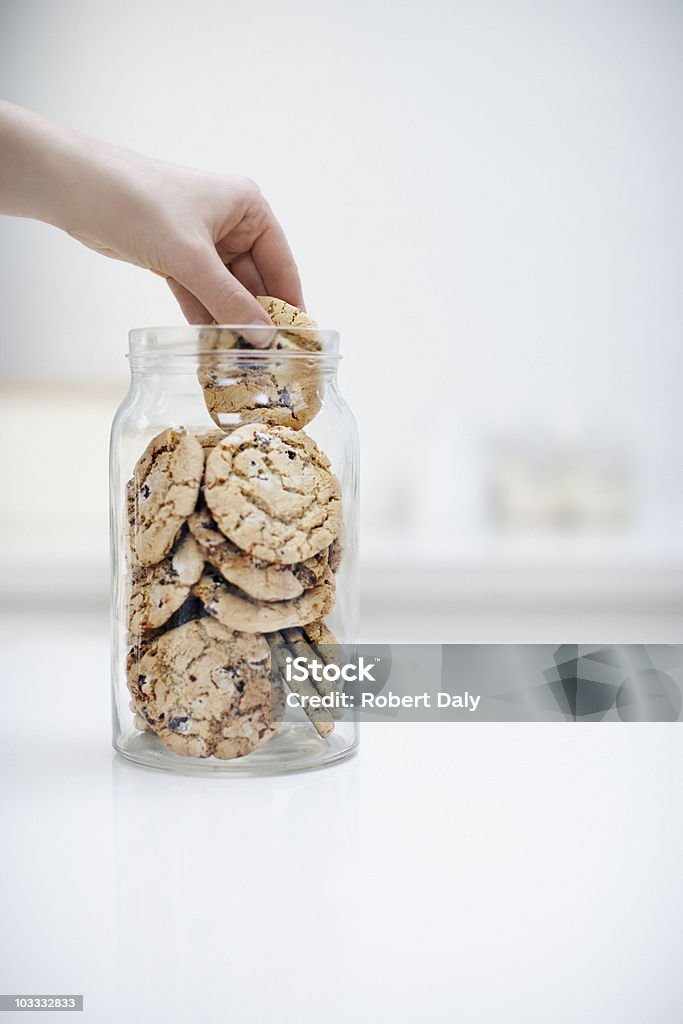 Ręka sięgania do cookie w słoiku - Zbiór zdjęć royalty-free (Ciasteczko)