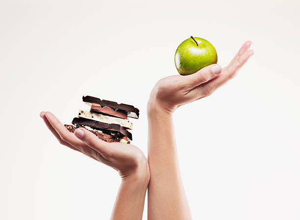 femme de ventouses pomme verte au-dessus des bars chocolat - matière grasse aliment photos et images de collection