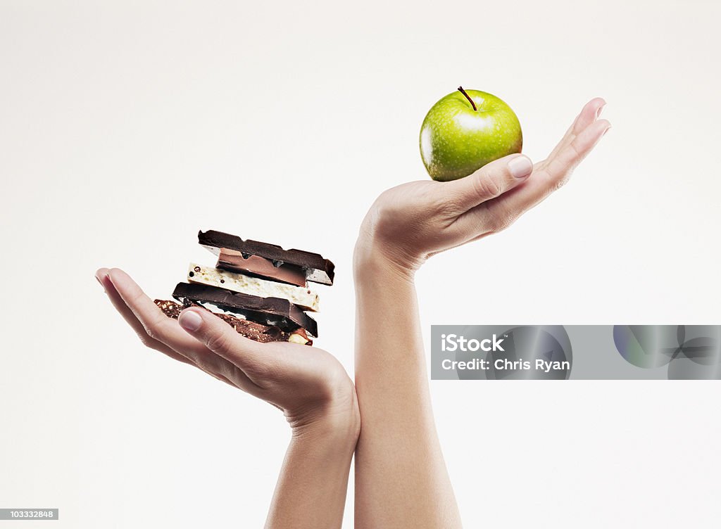Woman cupping green apple above chocolate bars  Healthy Eating Stock Photo