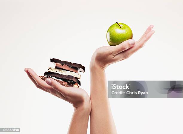 Woman Cupping Green Apple Above Chocolate Bars Stock Photo - Download Image Now - Healthy Eating, Weight Scale, Dieting