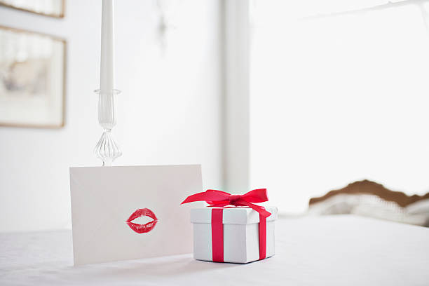 boîte de cadeau avec ruban et carte avec trace de rouge à lèvres sur un bureau - valentine present photos et images de collection