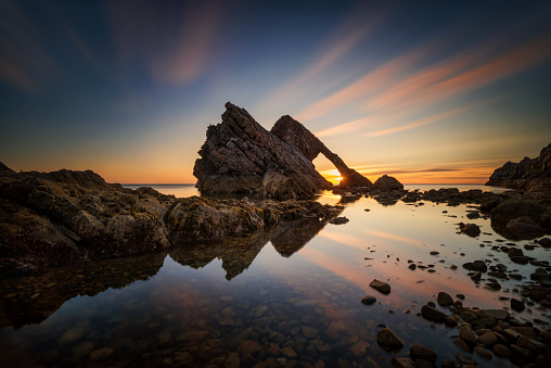 Bow Fiddle Rock reflection in sunrise light, Portknockie, Scotland