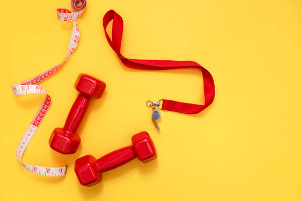 istock Two red dumbbells, tape measure and whistle 1033357934
