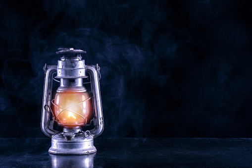 Old gas lantern on black table and foggy and smoke dark and night scenery