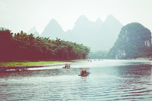 mirador del bambú pequeño turismo balsas navegando por el río li entre verdes bosques y las montañas karst en yangshuo county de guilin, china. yangshuo es un popular destino turístico de asia. - xingping fotografías e imágenes de stock