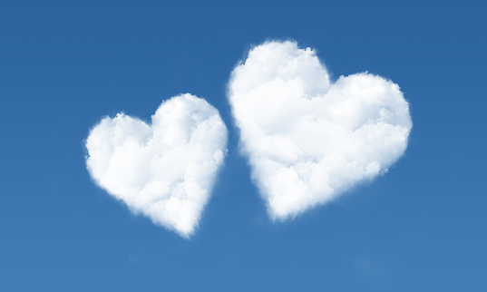 Two heart shaped clouds in the blue sunny sky.