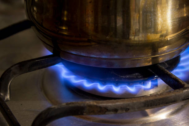 istock Steel casserole pot being heated by a stove. 1033391330