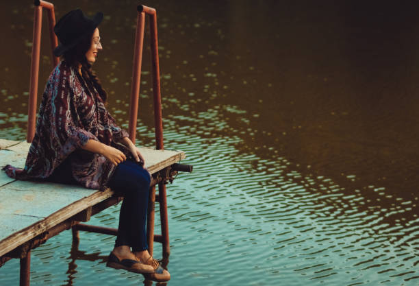 istock Young woman relaxing on jetty above lake 1033391386