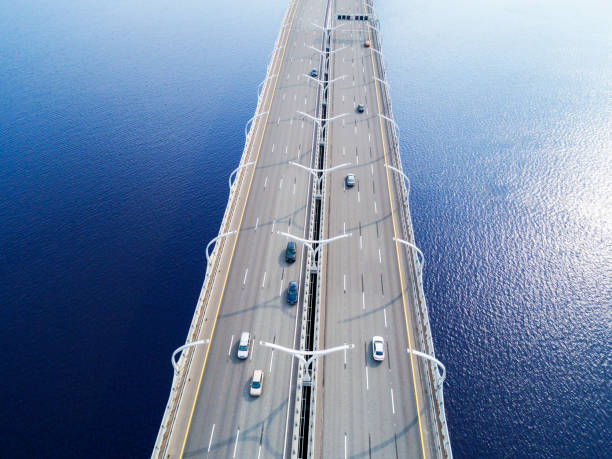 海の高速道路の空撮。車橋インターチェンジを横断陸橋します。トラフィックを高速道路のインターチェンジ。空中の鳥の目の高速道路。高速道路。道路のジャンクション。通過する車。ト� - traffic sea passage overpass car ストックフォトと画像