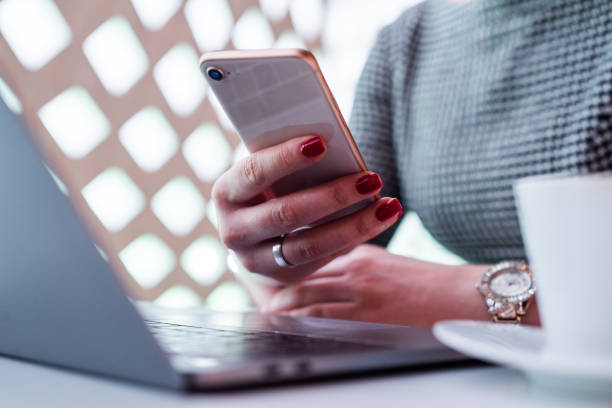 Close up of unknown female using smart phone in her office.