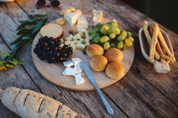 Home made cheese and various food on a rustic, wooden table.
