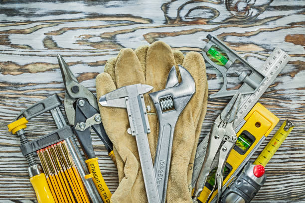 Leather working gloves construction tooling on wooden board.
