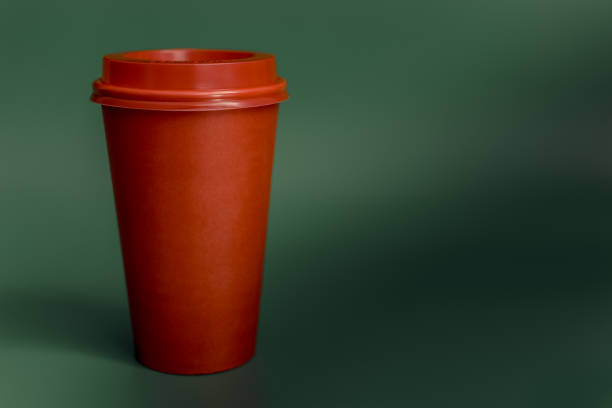 istock red paper Cup isolated on green background 1033473904
