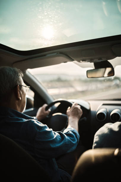istock Experienced older man with glasses drives a car 1033508400