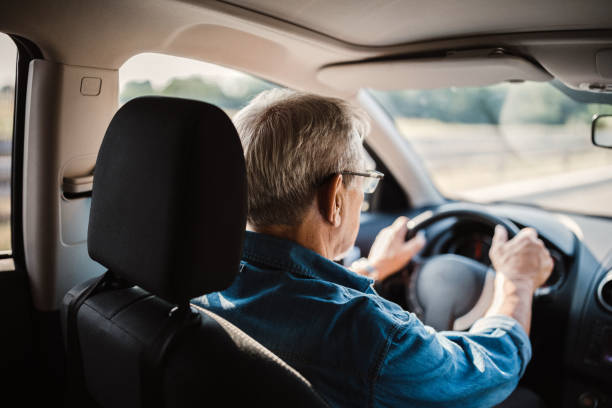 istock Experienced older man with glasses drives a car 1033509172