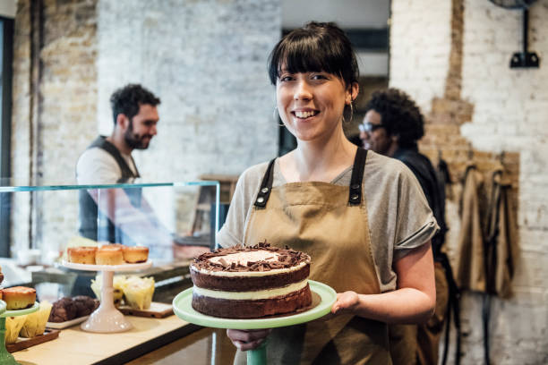 istock Young woman with cake on stand in cafe smiling 1033525822