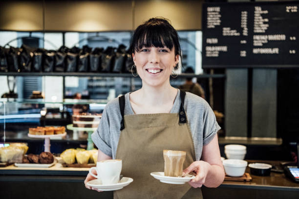 istock Barista holding coffee smiling at camera 1033525824