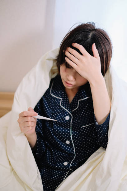 istock woman taking her own temperature 1033557236