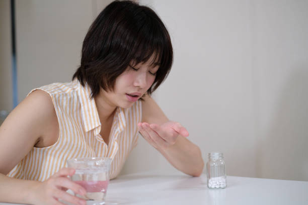 istock woman taking cold medicine 1033559072