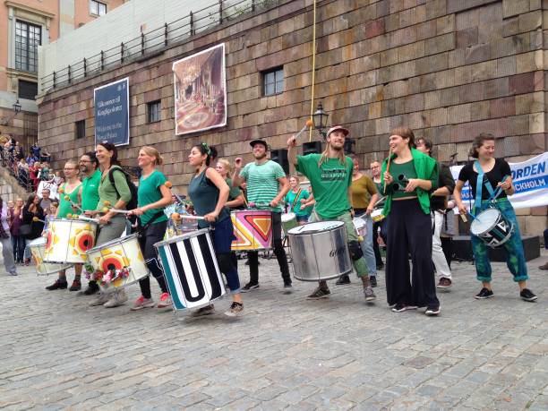 Climate Change Cacophony 8th August, 2018.  Main Palace Square, Stockholm, Sweden.  A band of pro Earth conservationist drummers plays to a crowd of protesters who have come up o the square to protest against climate change. mcdermp stock pictures, royalty-free photos & images
