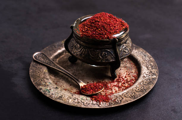 Traditional asian spice sumac Traditional asian spice sumac in metallic utensil on dark background. Selective focus. sumac spice stock pictures, royalty-free photos & images