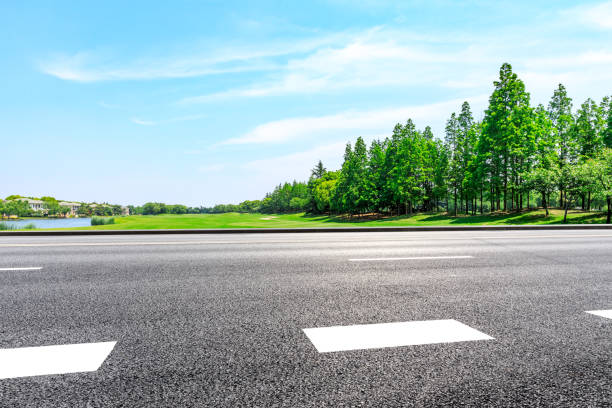 istock Empty asphalt road and green woods under blue sky 1033643802