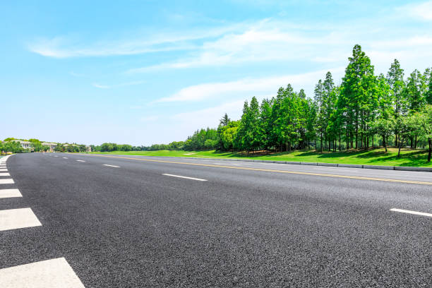 istock Empty asphalt road and green woods under blue sky 1033643950