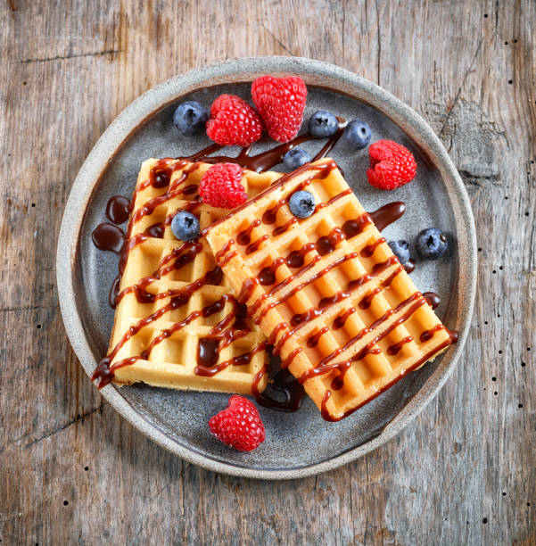 plate of waffles on rustic wooden table, top view