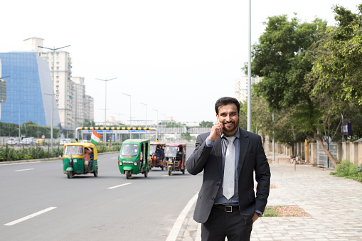 Indian businessman talking on mobile phone on the way to work