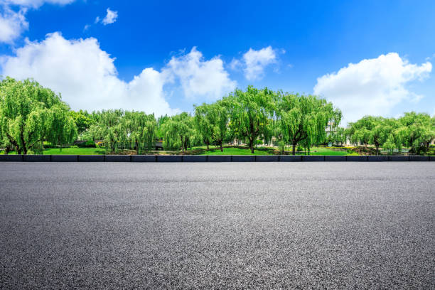 istock Empty asphalt road and green woods under blue sky 1033651458
