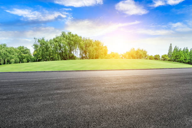 istock Empty asphalt road and green woods at sunset 1033654888