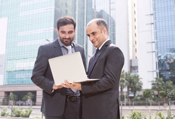 istock Two businessmen with laptop in city 1033657704