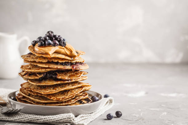 stack vegan blueberry pancakes with peanut butter and syrup. - pancake buttermilk buttermilk pancakes equipment imagens e fotografias de stock