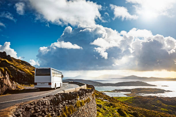 Tourist bus traveling Tourist bus traveling on mountain road. Ring of Kerry, Ireland. Travel destination county kerry photos stock pictures, royalty-free photos & images
