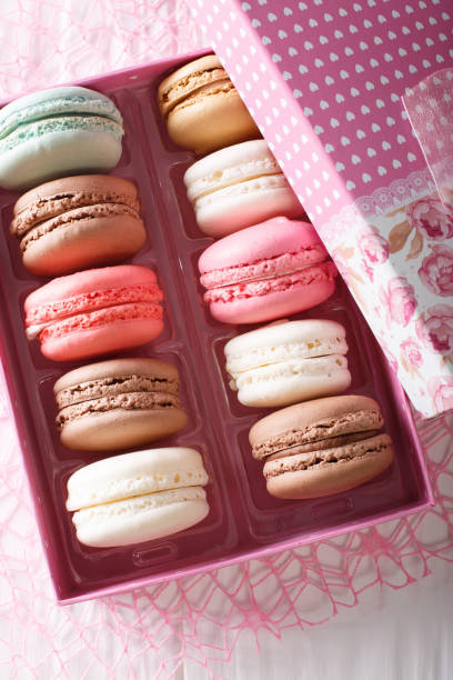 istock Multicolored macaroons in a gift box close-up on a table. Vertical top view 1033673086