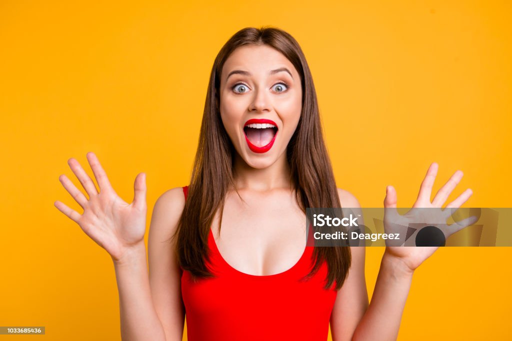 Bouchent portrait de choc gesticulant fille étonné, extrêmement heureux, avec des yeux grands ouverts et la bouche, debout sur un fond jaune clair - Photo de Femmes libre de droits