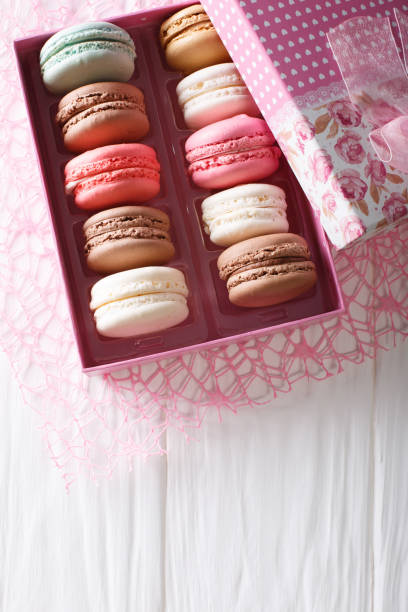 istock Beautiful food: French macaroons in a gift box close-up on a table. Vertical top view 1033694584