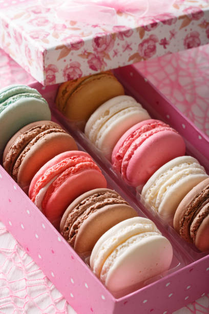 istock Delicious macaroons in a pink gift box macro on a table. vertical 1033694728