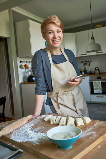 istock Happy woman baking bread in the kitchen 1033703400