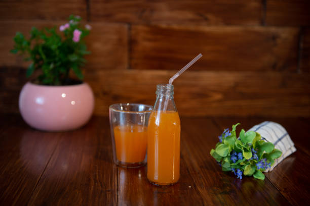 istock Fresh juice in bottle on wooden table 1033703848