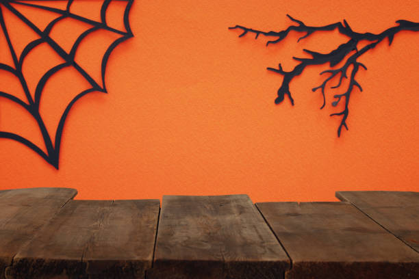istock Halloween holiday concept. Empty rustic table in front of Spider webs over orange background. Ready for product display montage. 1033703872