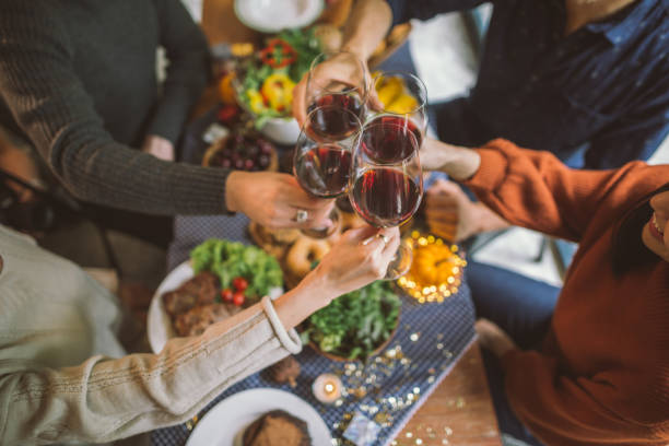 istock Friends clinking glasses above food on dinner table 1033704050