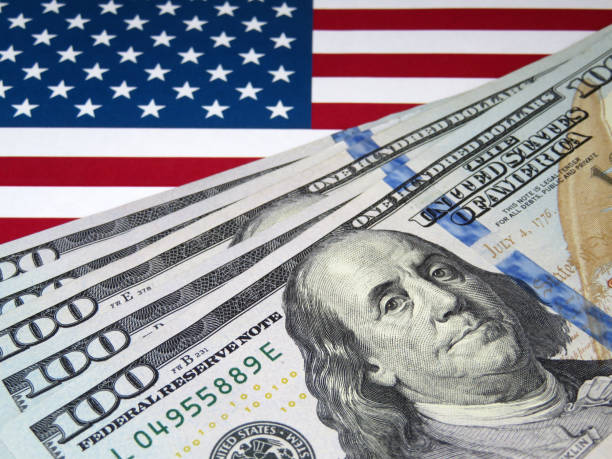 istock US dollars on background of US national flag 1033707540